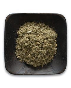 A wooden bowl filled with a pile of green powder on a white background.