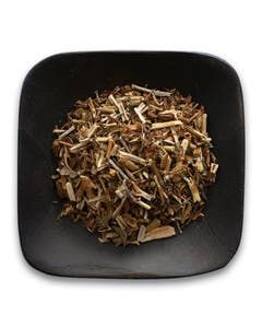 A black bowl filled with dried herbs on a white background.