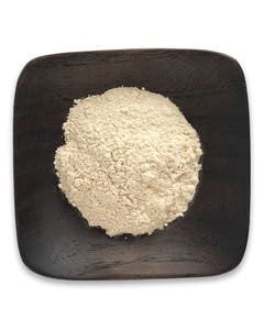 A wooden plate topped with a pile of powder on a white background.