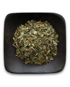 A wooden bowl filled with dried mint leaves on a white background.