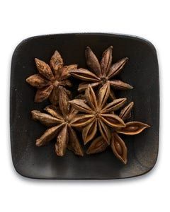A black plate topped with star anise on a white background.