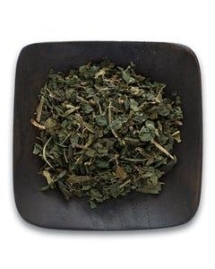 A square bowl filled with dried mint leaves on a white background.