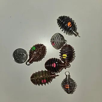 A group of pendants are sitting on a table next to a quarter.