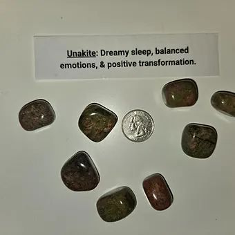 A pile of stones next to a penny on a table.