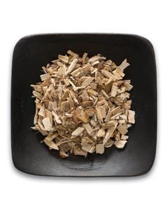 A black square plate topped with a pile of wood chips.
