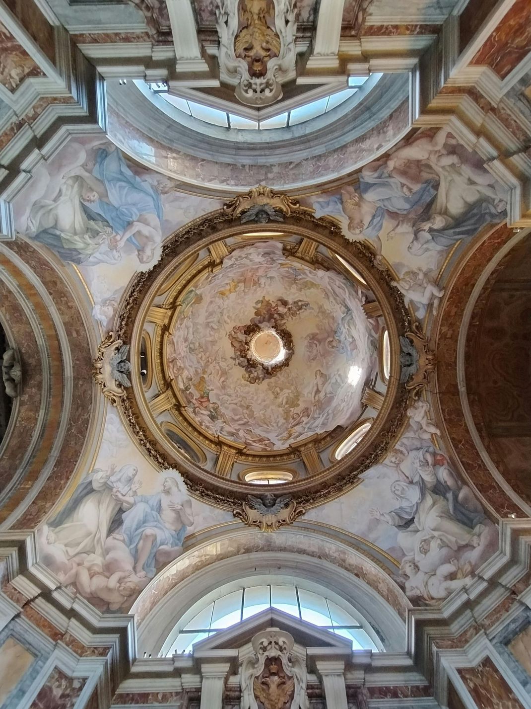Looking up at the ceiling of a church with a dome