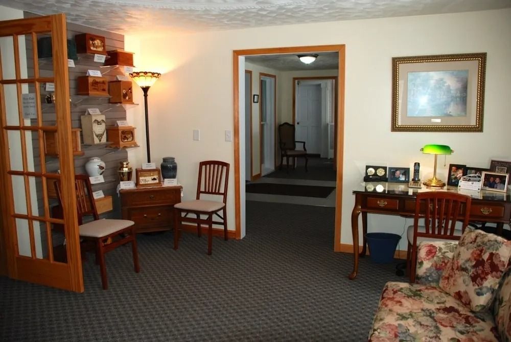 Interior room with furniture, urns displayed, and a doorway leading to another room.