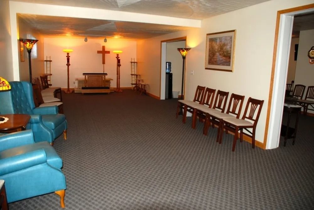 Interior of a funeral home, with seating, altar, and stained glass lamps.