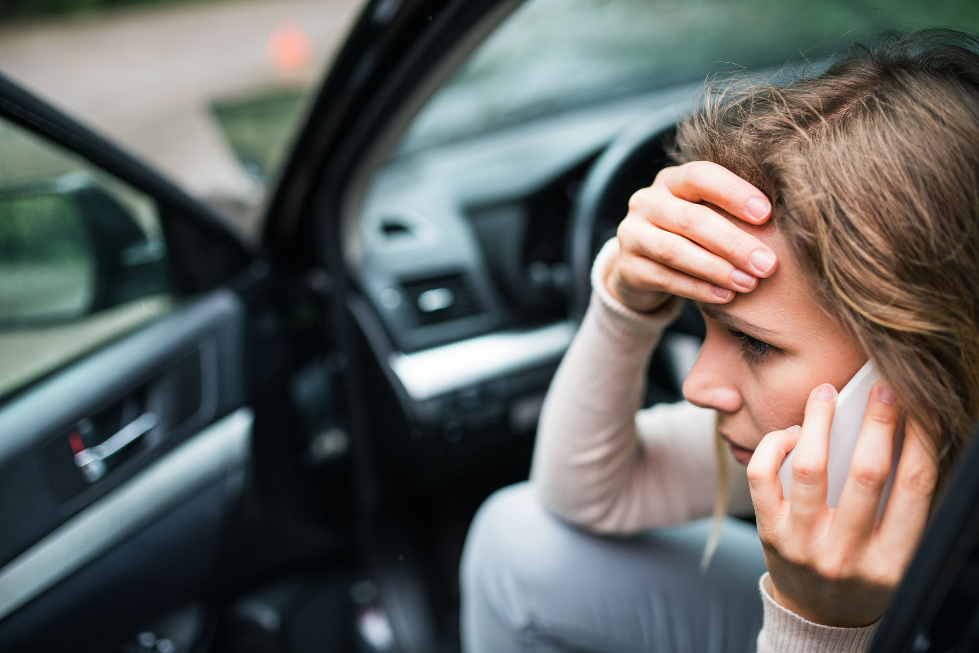 Woman sitting in a car, looking distressed while talking on a cellphone Woman sitting in a car, looking distressed while talking on a cellphone