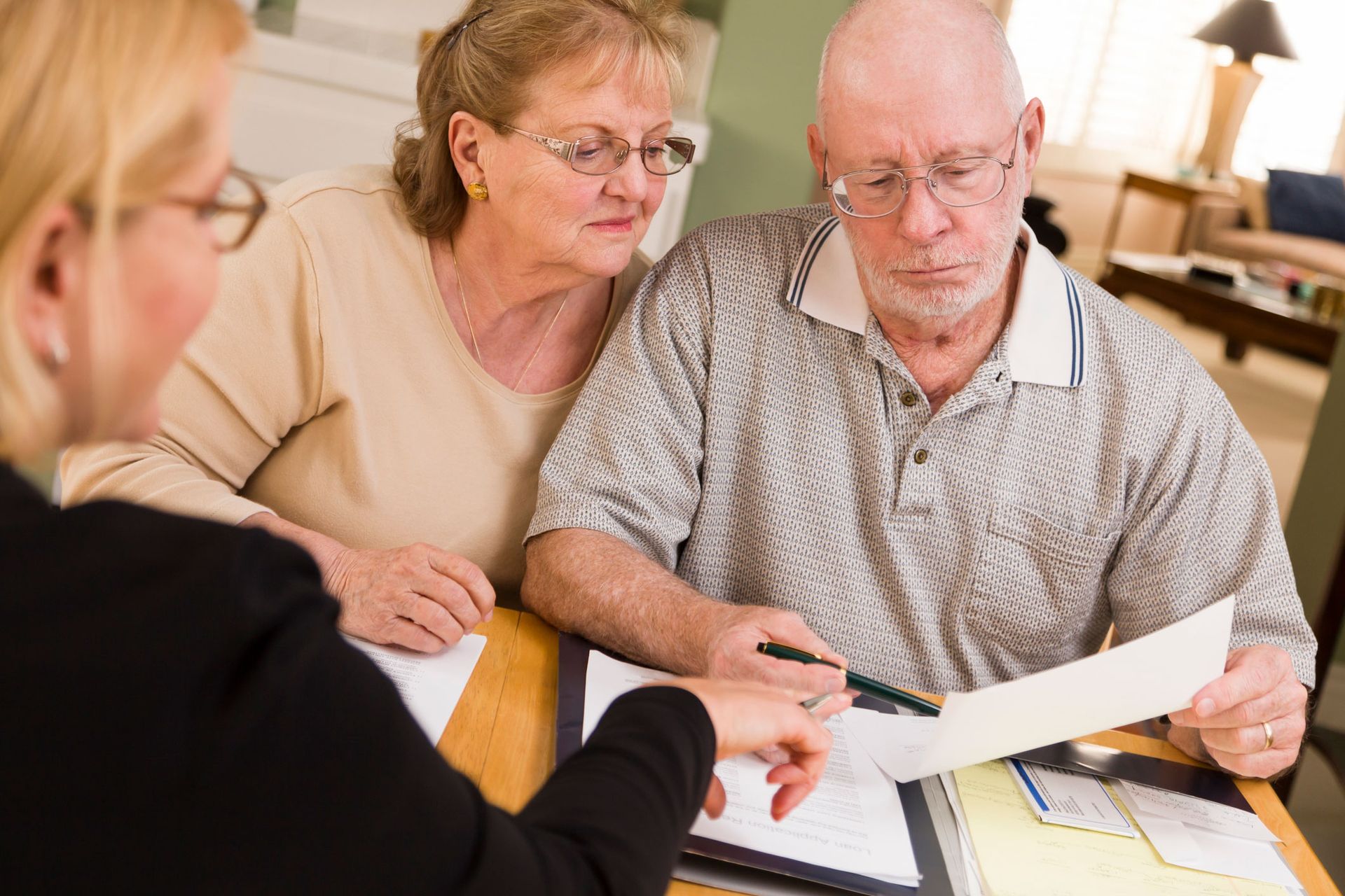 A senior couple reviewing documents at home with a slip and fall lawyer in Camden, NJ, from