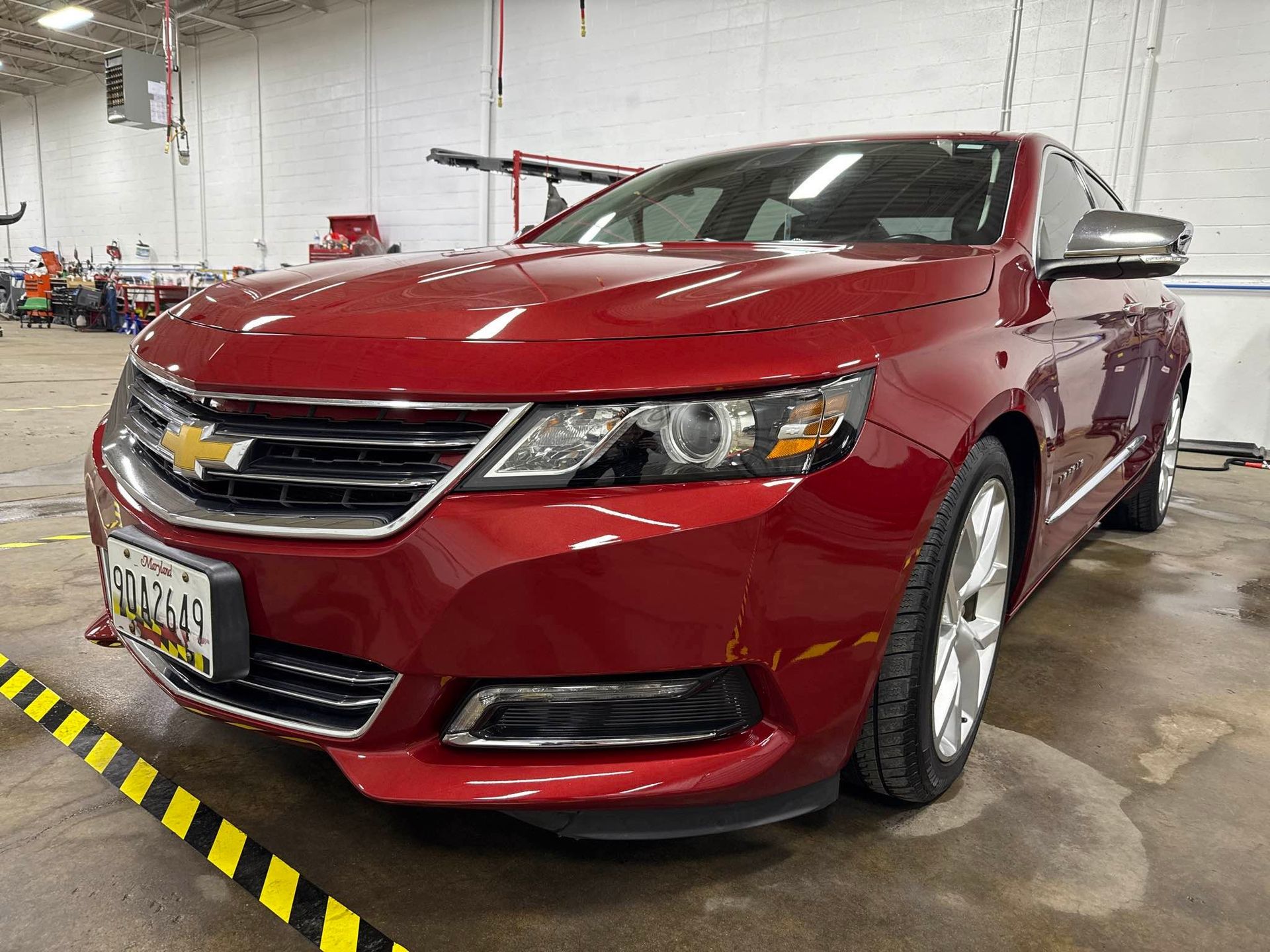 Red Chevrolet Impala sedan, parked indoors. Front view.