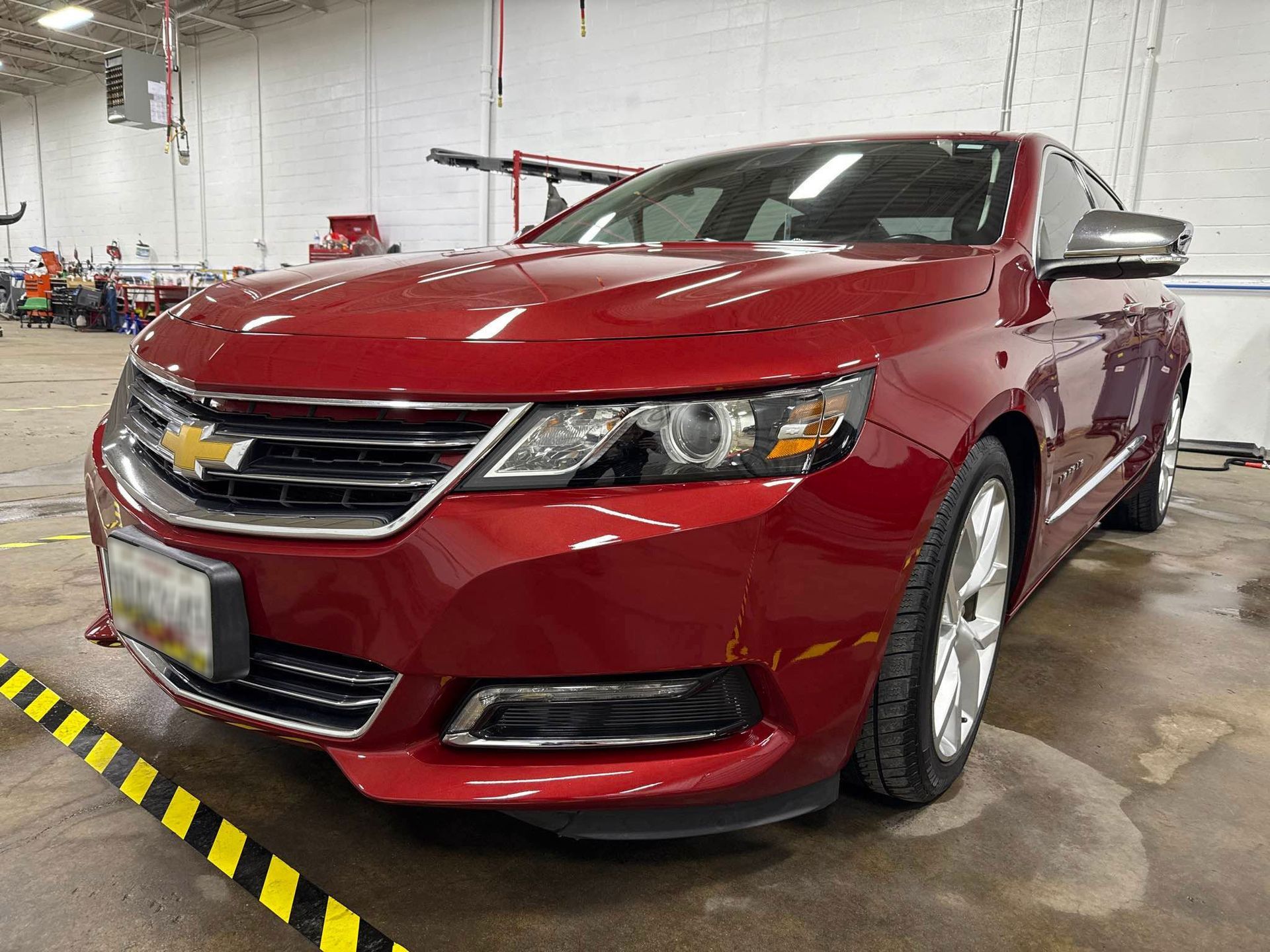 Red Chevrolet Impala sedan, parked indoors. Front view.
