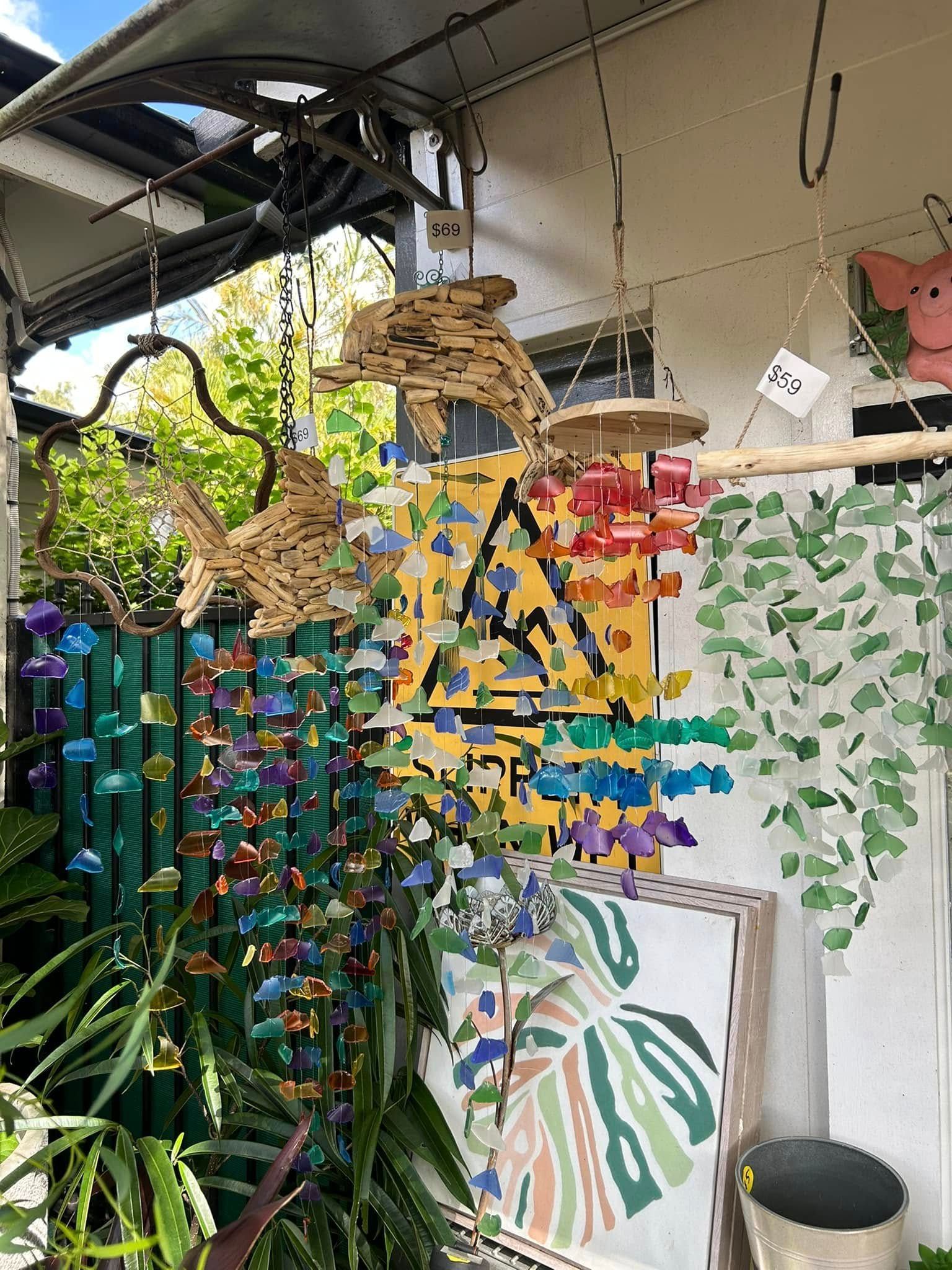 Shopfront Display With Colorful Wind Chimes, Wood Carvings — Hinterland Foliage in Caloundra, QLD