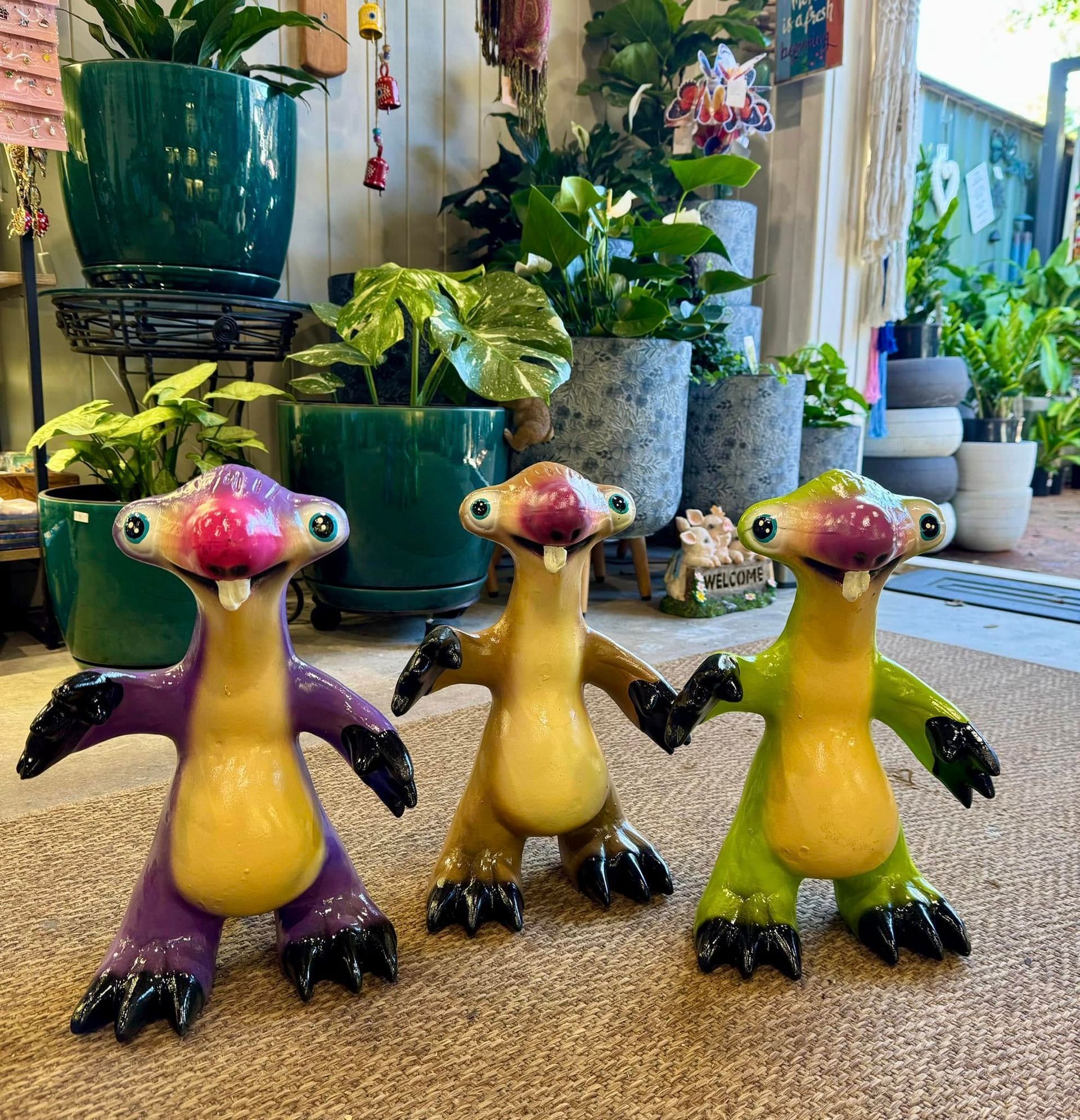 Three Colorful Cartoon Sloths in Front of Potted Plants — Hinterland Foliage in Landsborough, QLD