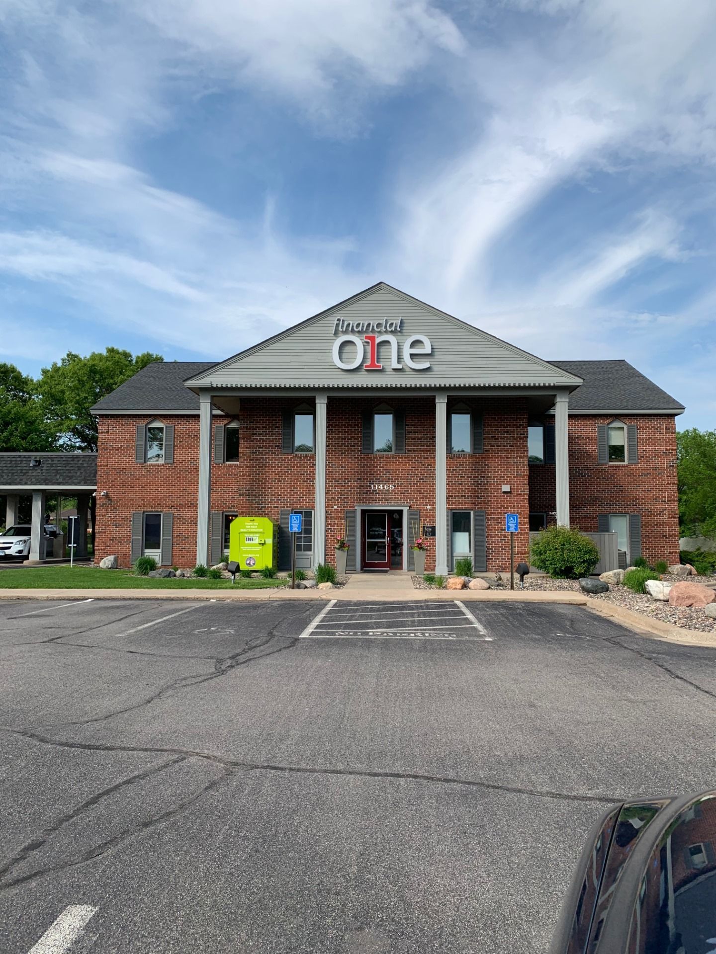 Brick building with love & one sign, two stories, light blue sky. Parking in front.