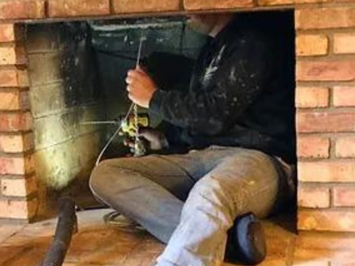 a person in a blue shirt is adjusting an air vent on the ceiling