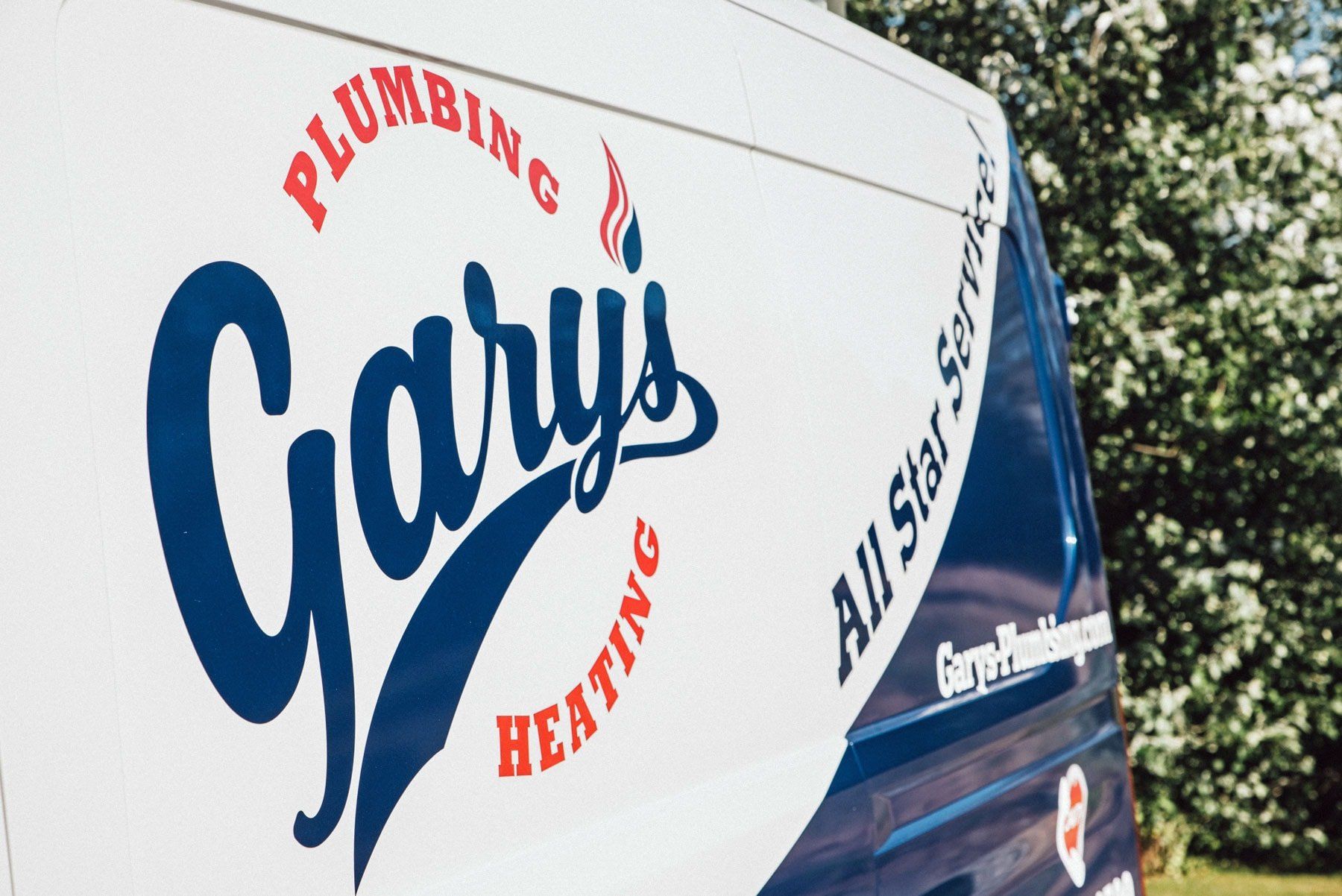 A blue and white gary 's plumbing and heating van