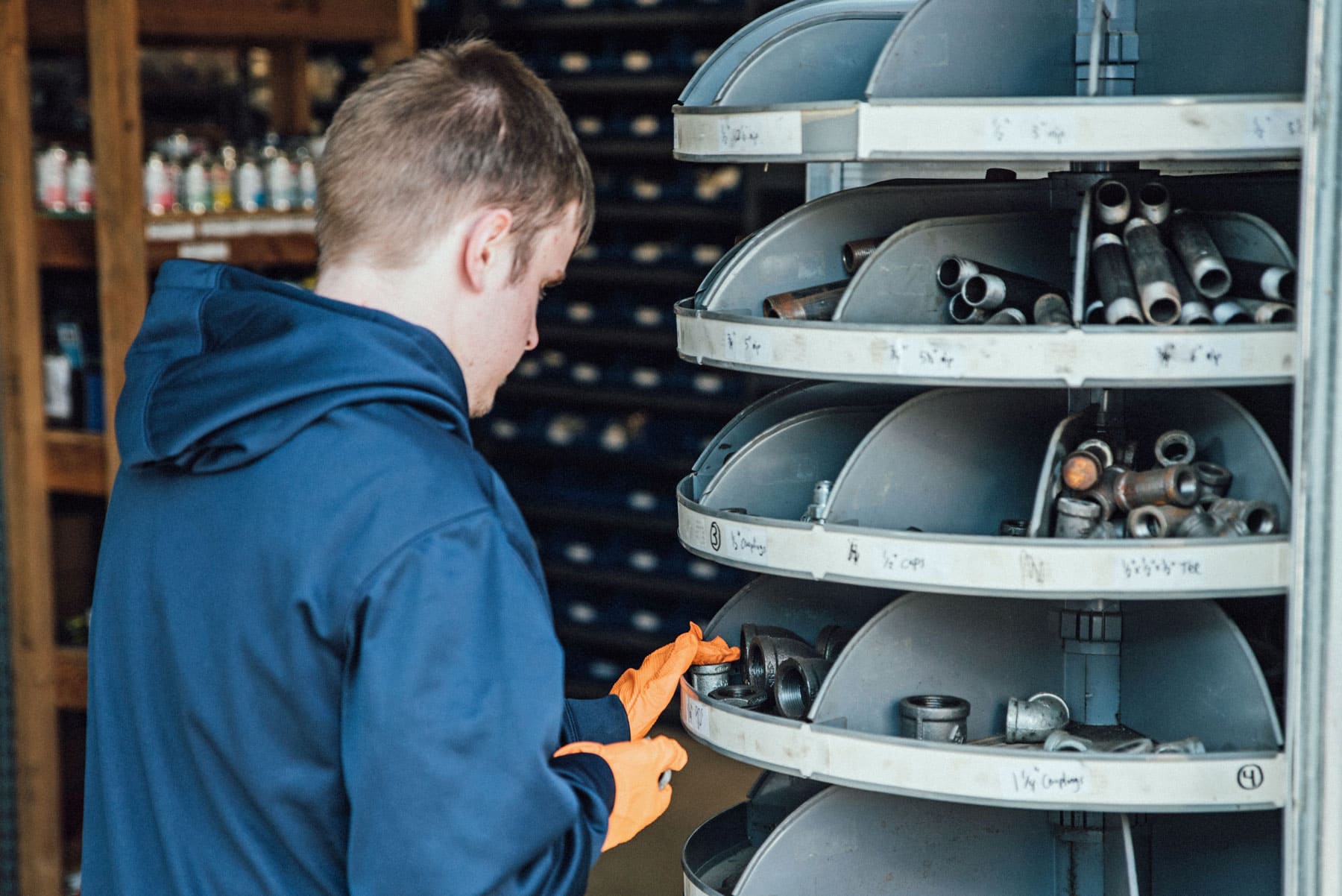 A man is looking at a shelf of pipes in a store.