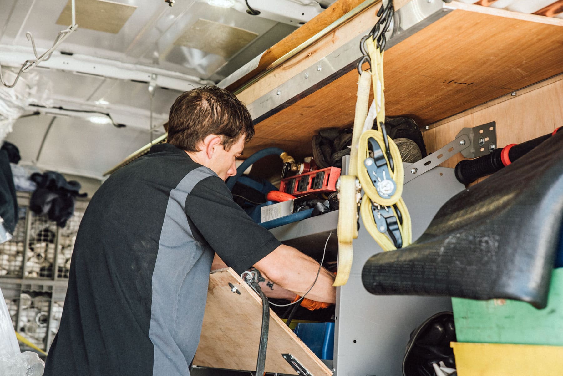 A man is working in the back of a van.