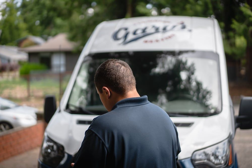 A man is standing in front of a white van.