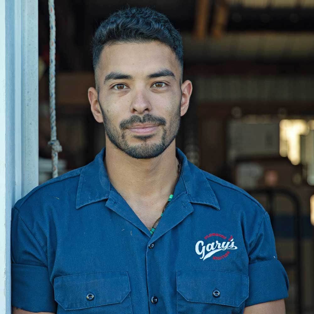 A man with a beard wearing a blue shirt that says garai