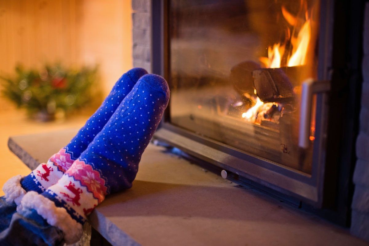 Photo of a girl in socks in front of a fireplace