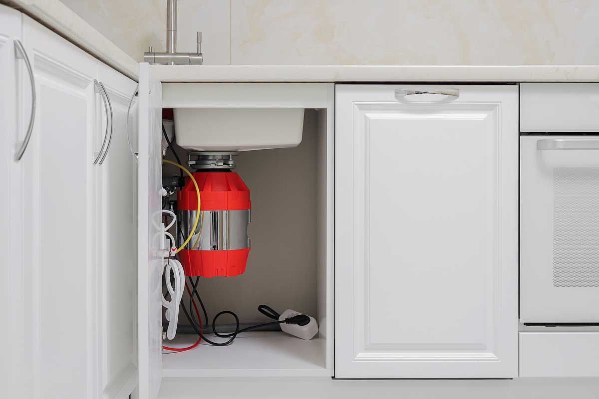 A kitchen sink with a garbage disposal underneath it.