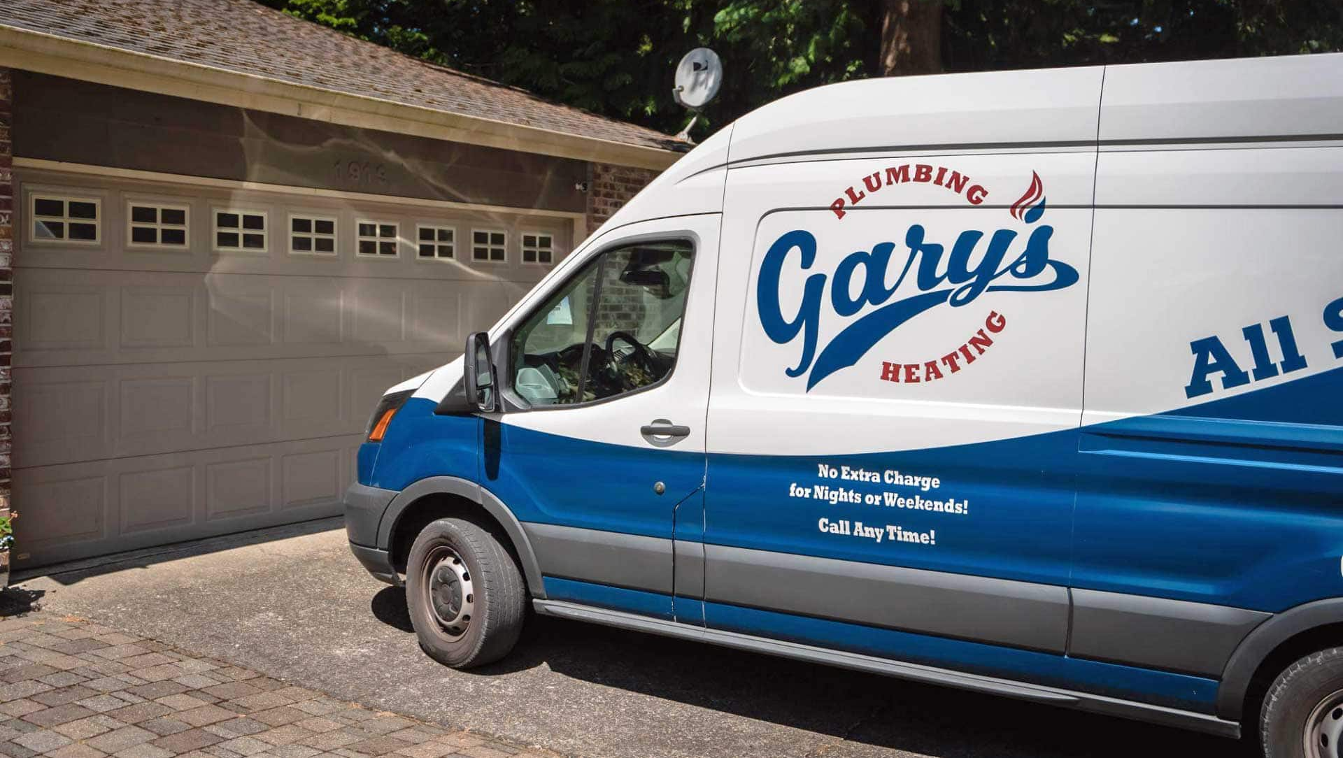 A blue and white gary 's plumbing van is parked in front of a garage door.