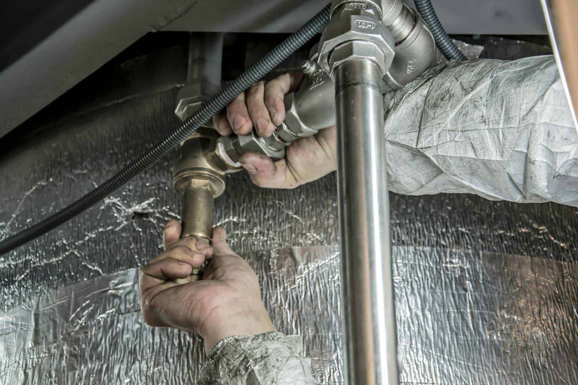 Checking under sink plumbing for leaks in spring