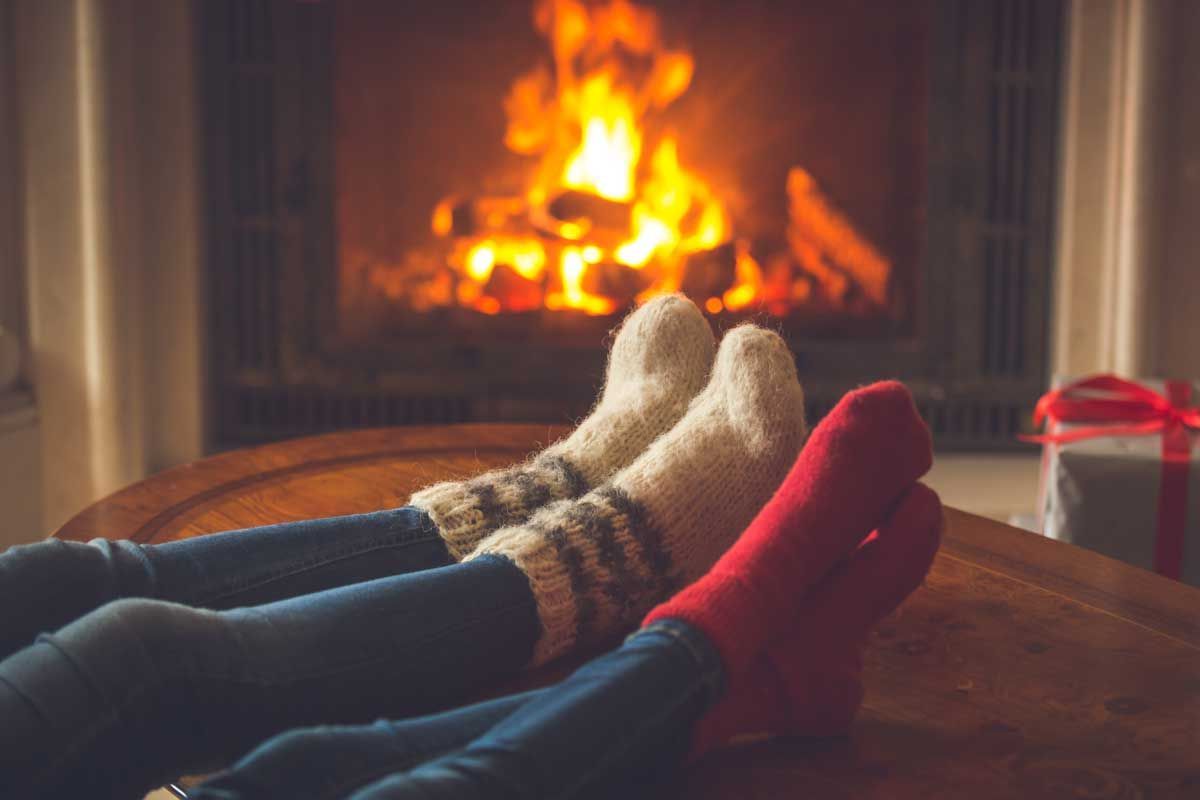 Photo of people wearing socks in front of a fireplace