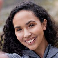 A woman with curly hair is smiling for the camera.