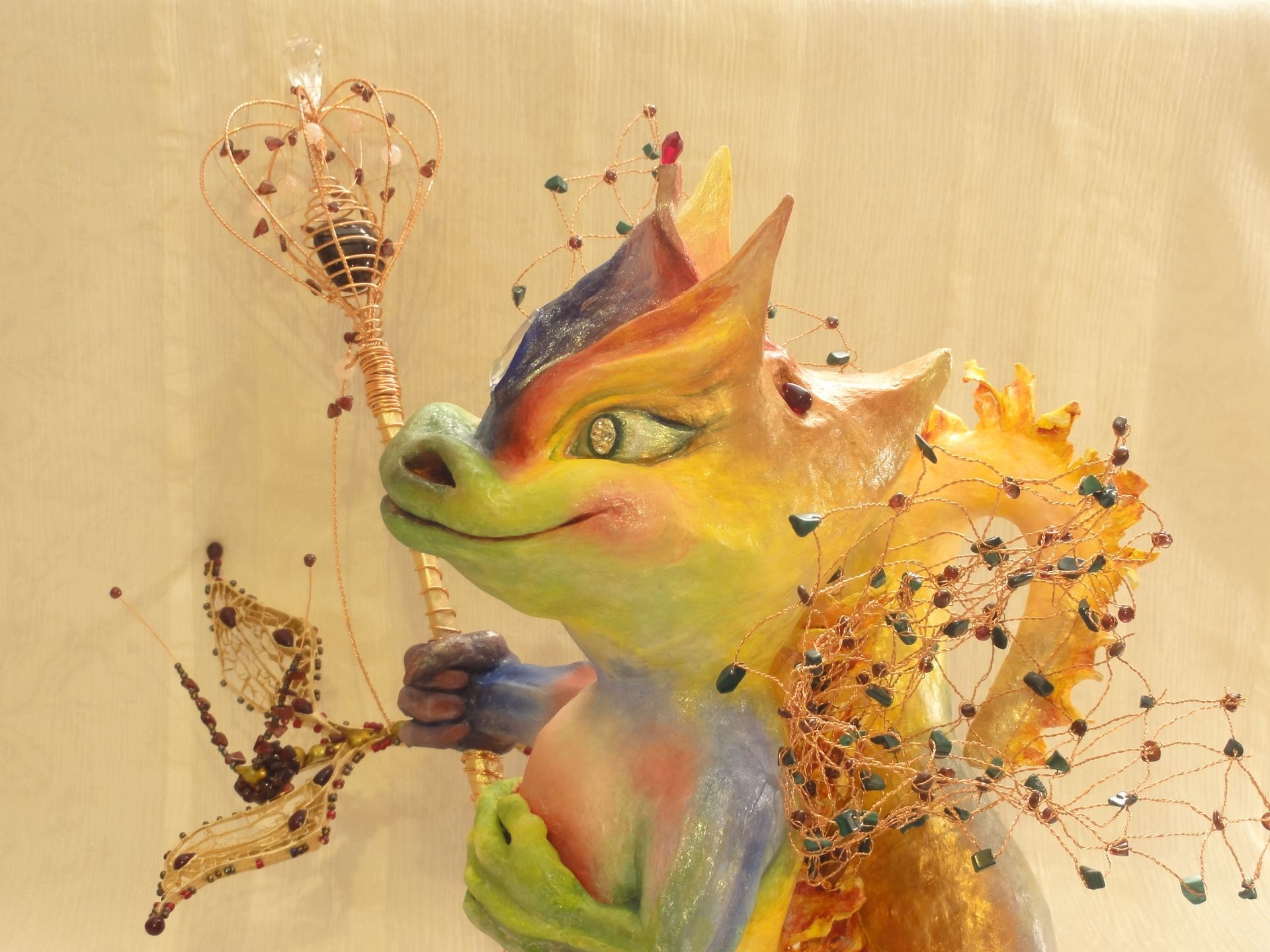 Eine bunte Statue eines Drachen mit einem Zauberstab