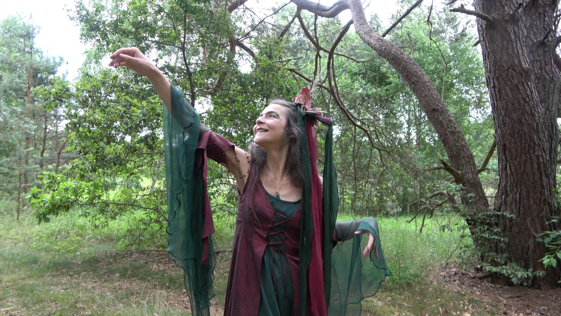 Eine Fee im grünen Kleid tanzt im Wald