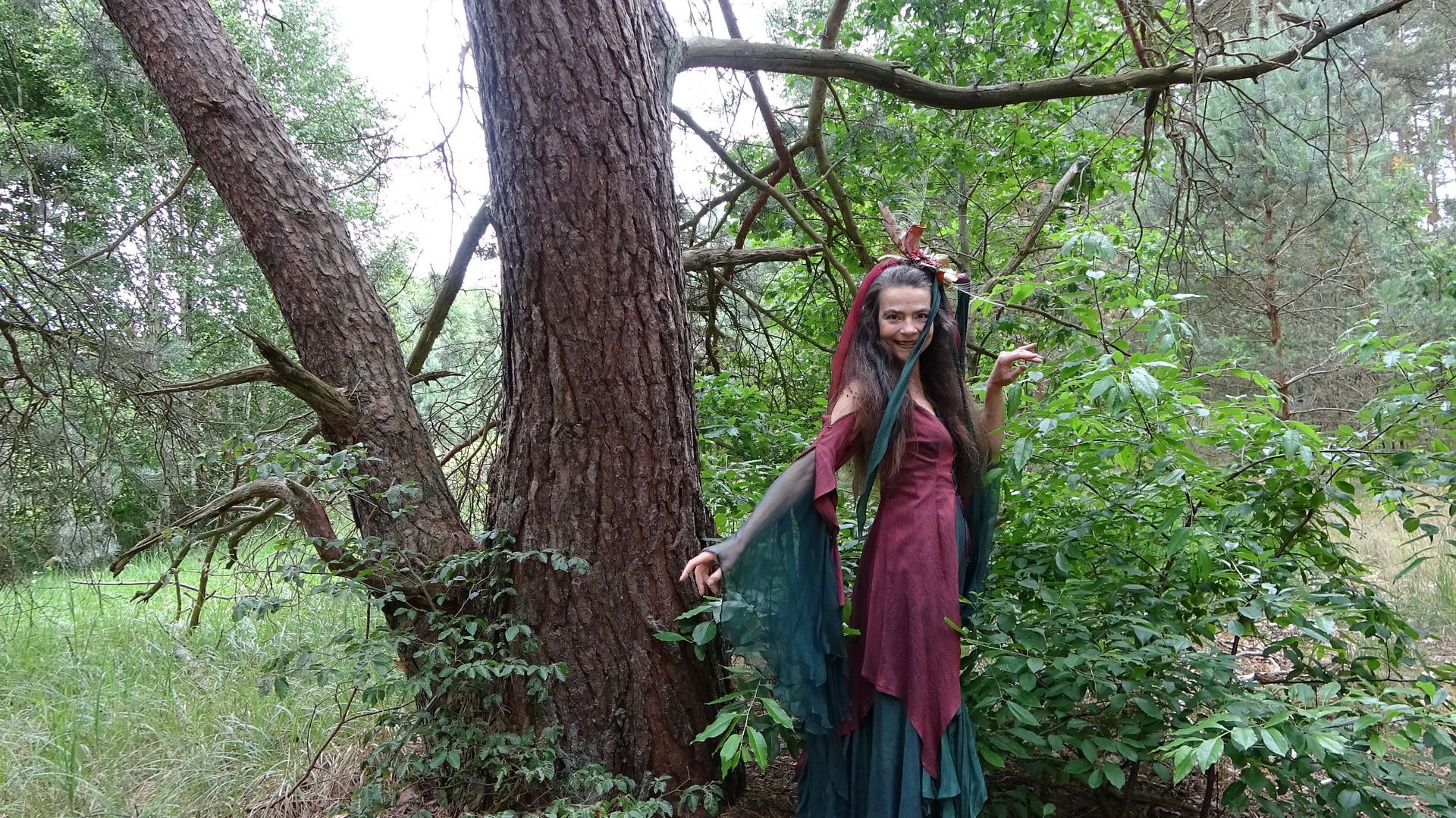 Eine Fee steht im Wald und lacht