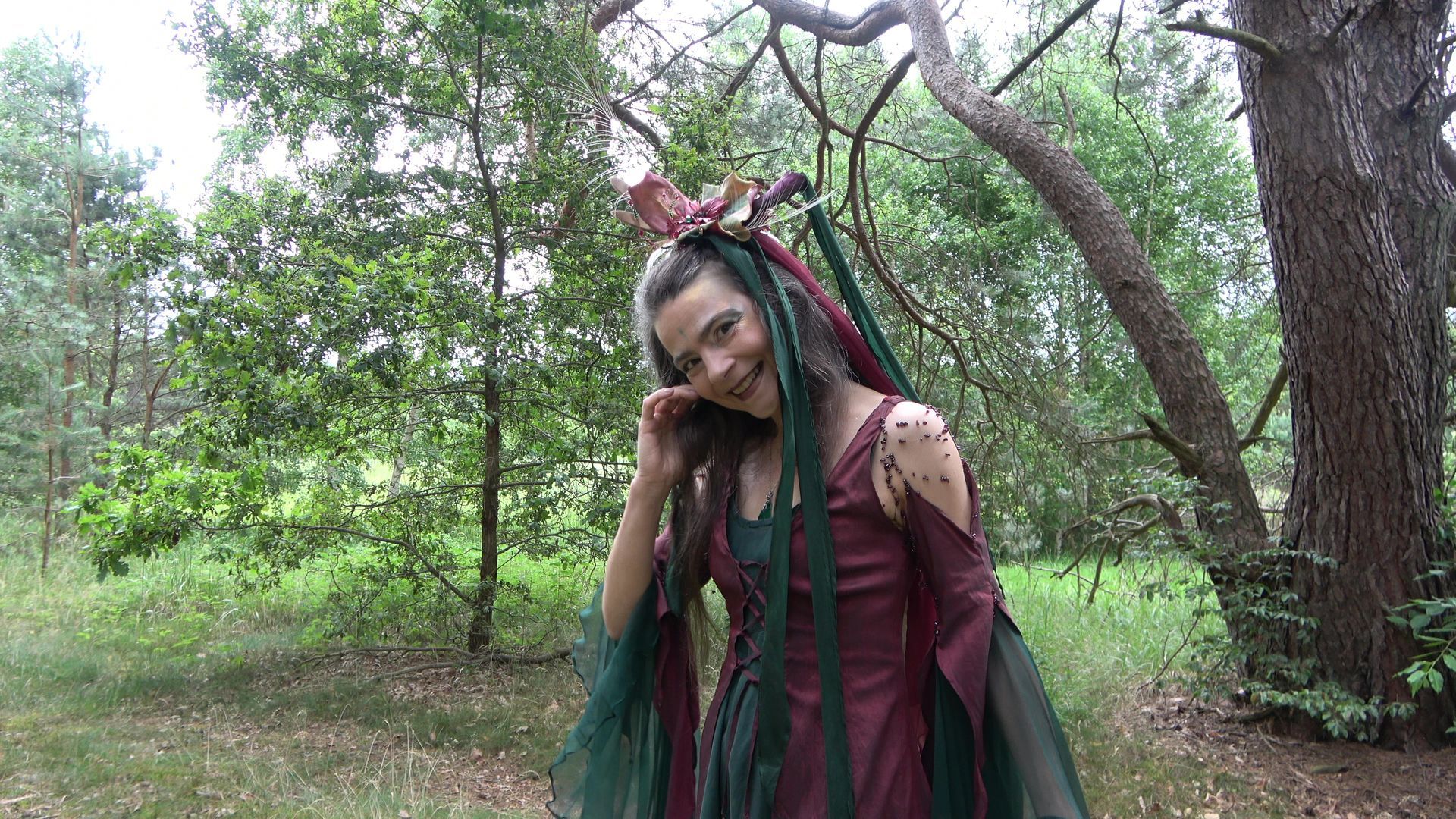 Eine Frau im Feen kleid steht im Wald