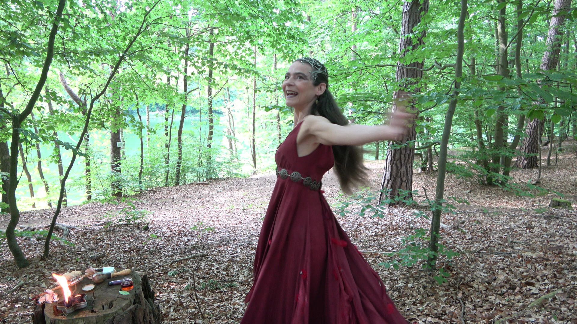 Eine Feuerfee im roten Kleid tanzt im Wald