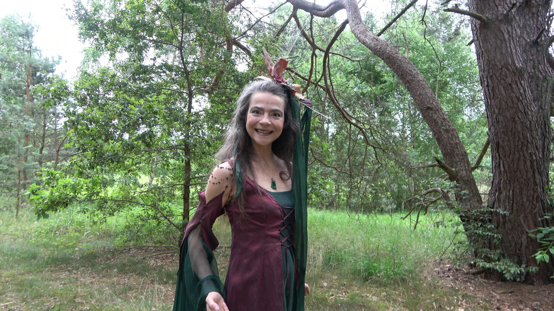 Eine Fee im grünen Kleid tanzt im Wald
