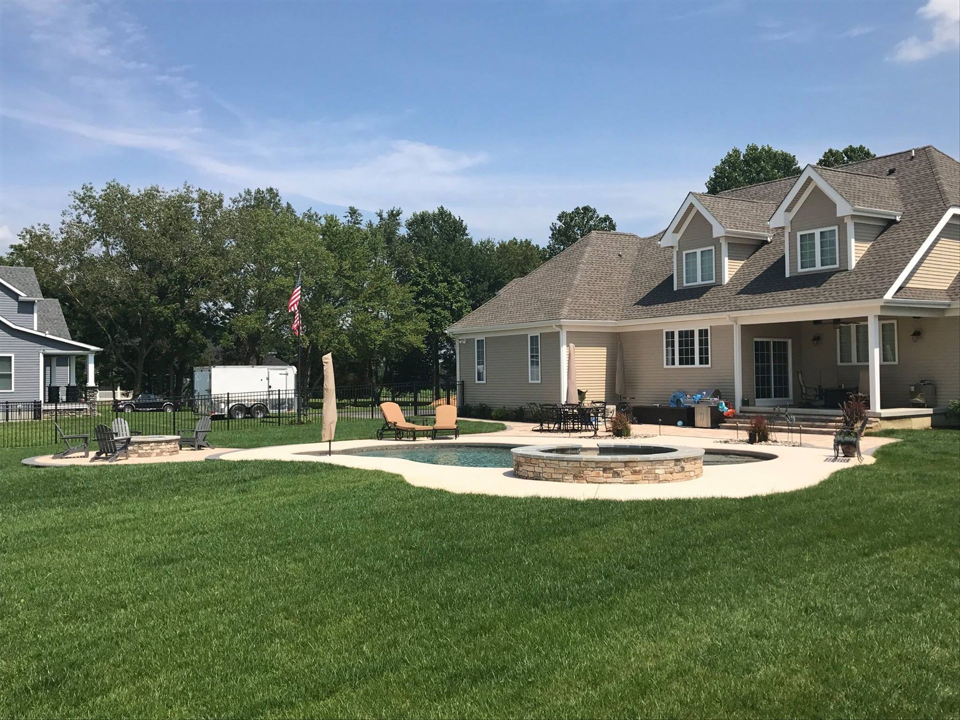 A large house with a swimming pool and a fire pit in the backyard.