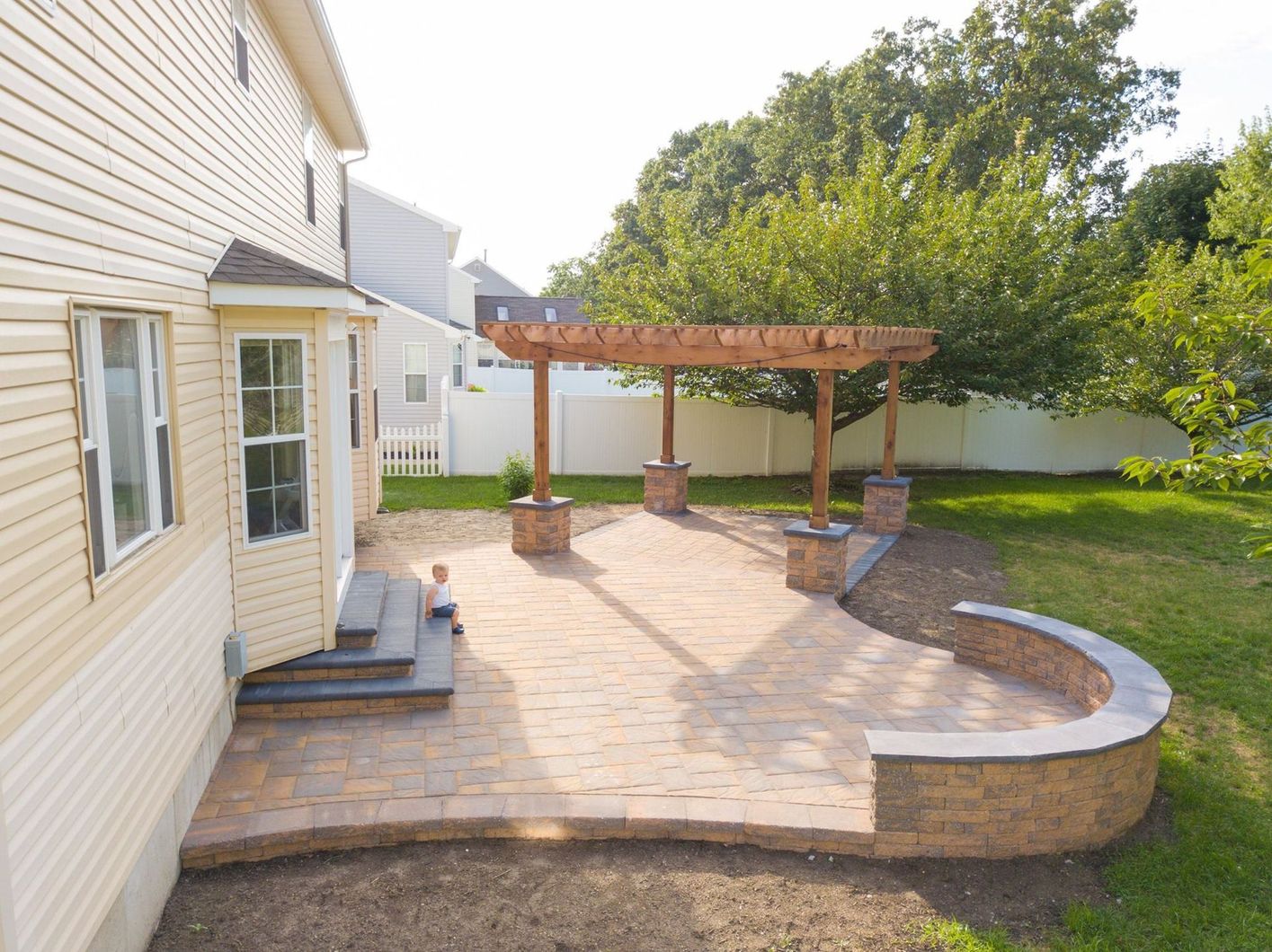 The backyard of a house with a patio and a pergola