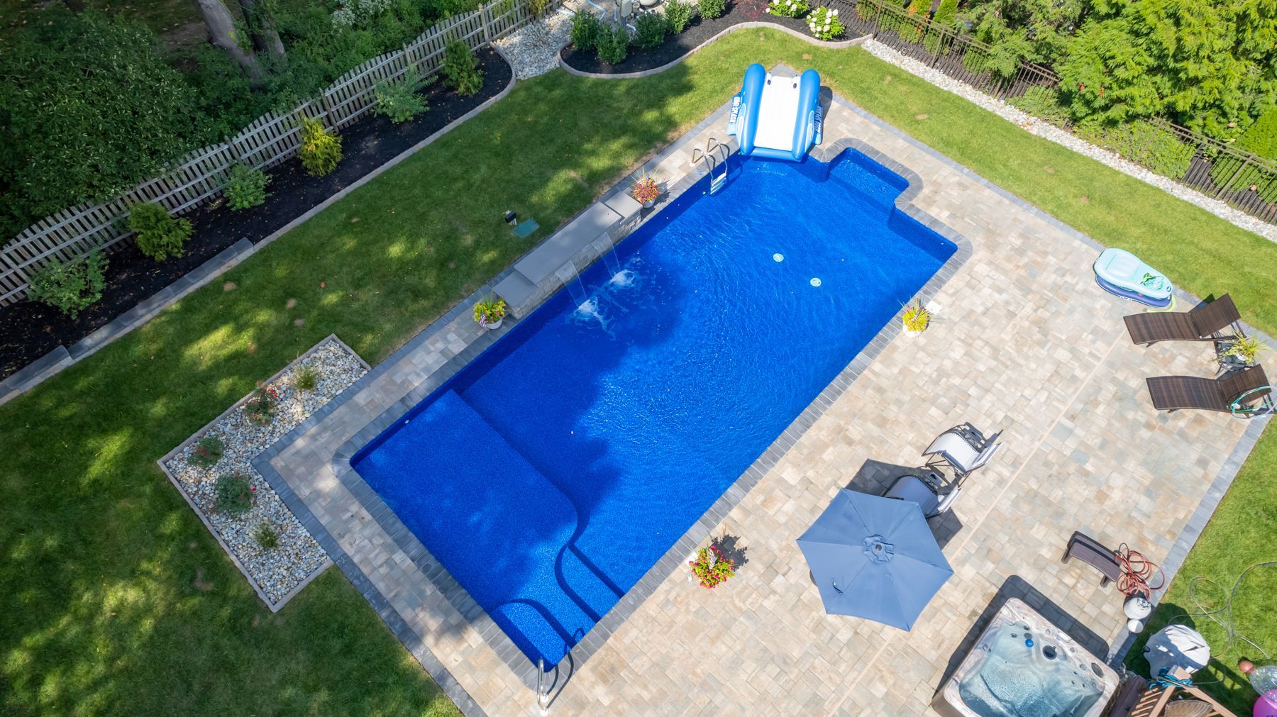 An aerial view of a large swimming pool in a backyard.