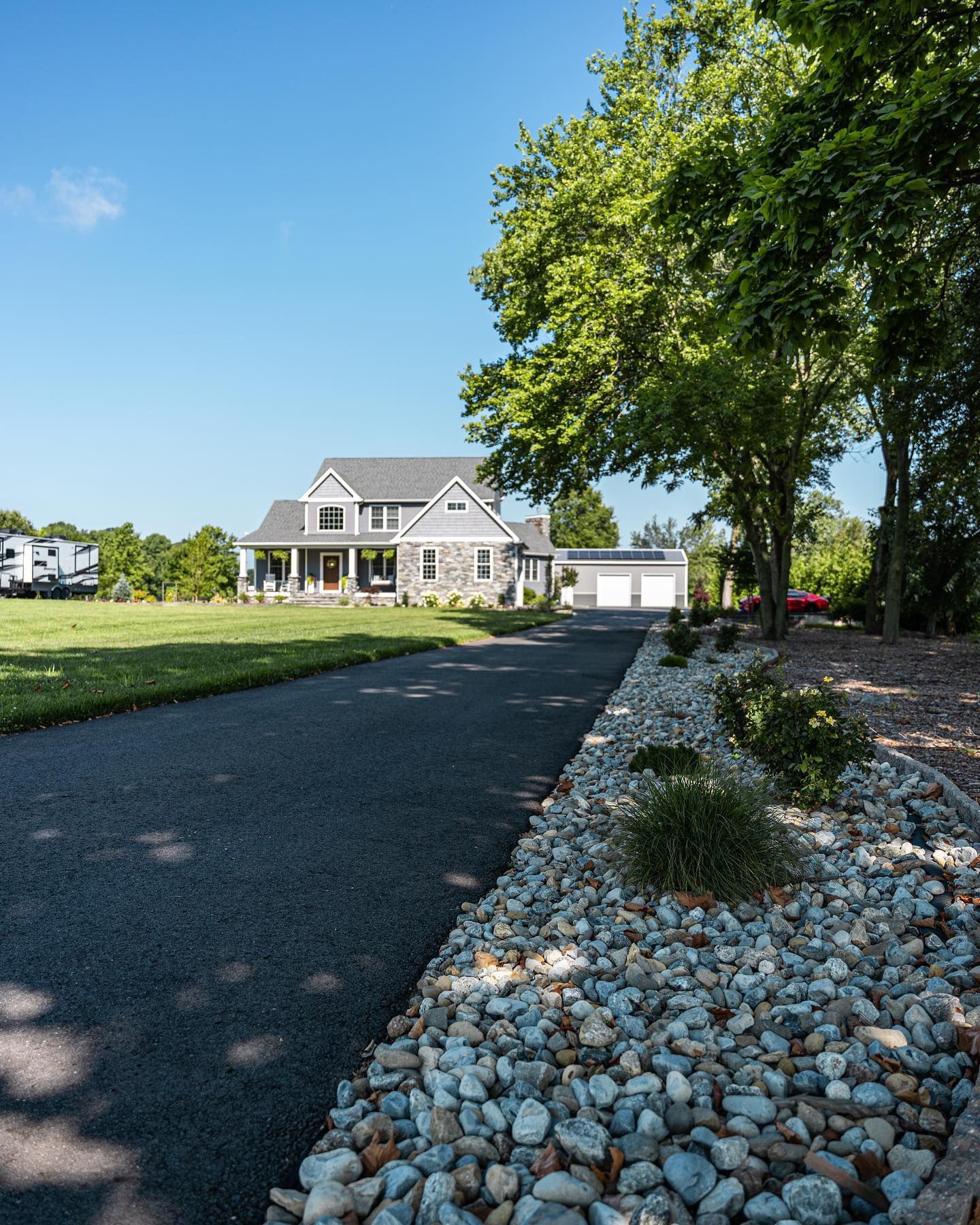A driveway leading to a house with a lot of rocks on the side