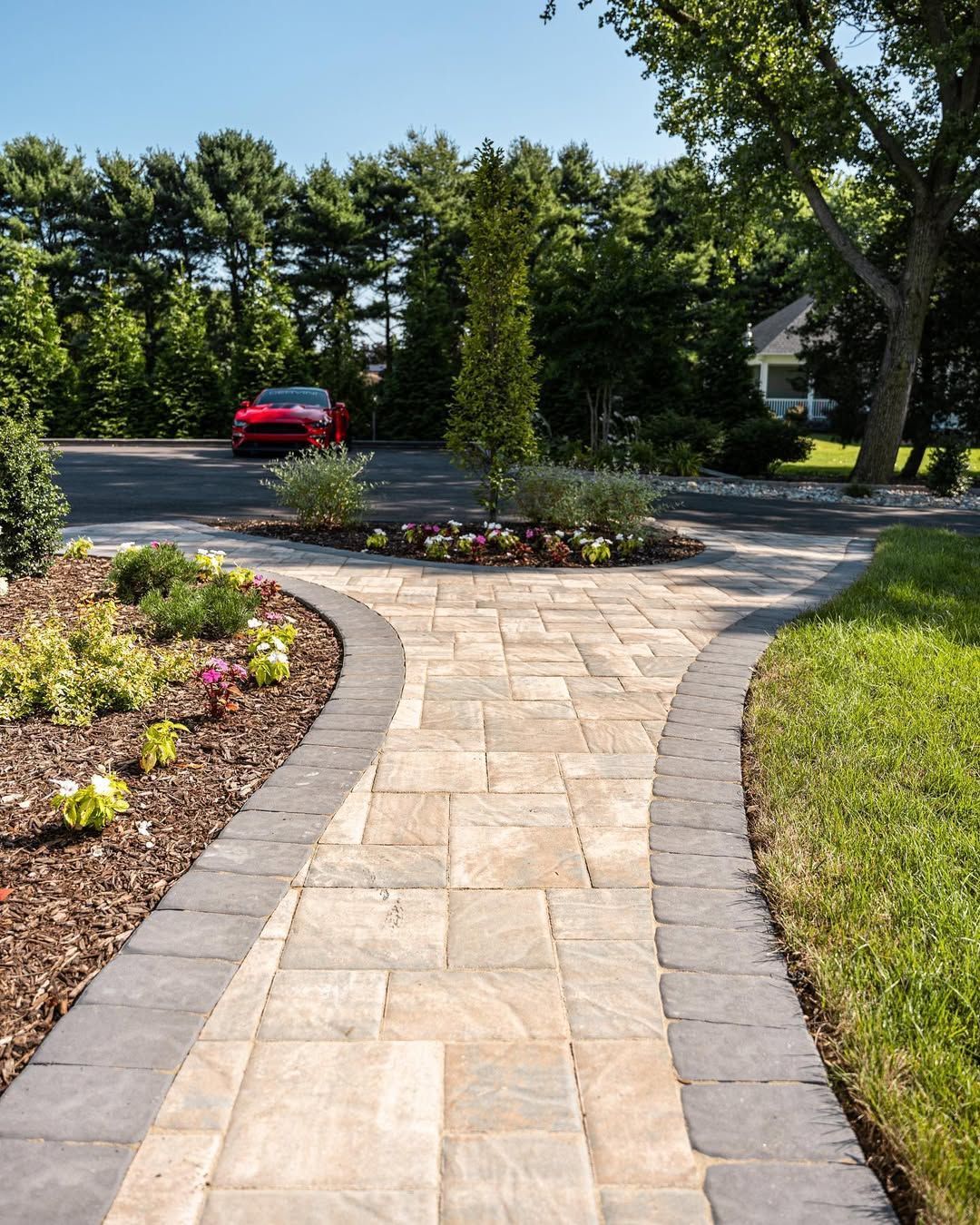 A large house with a red tile roof is sitting on top of a lush green field.