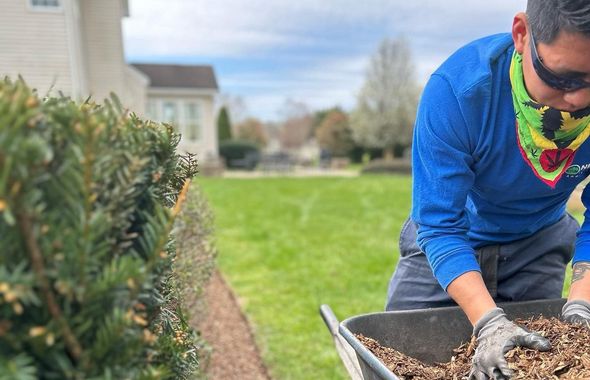 A man is loading dirt into a wheelbarrow.