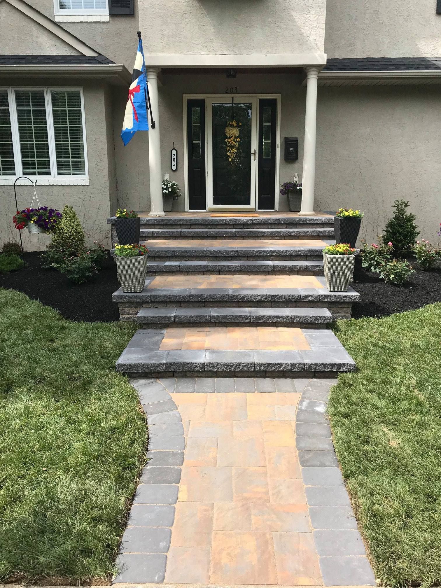 A brick walkway leading to the front door of a house.