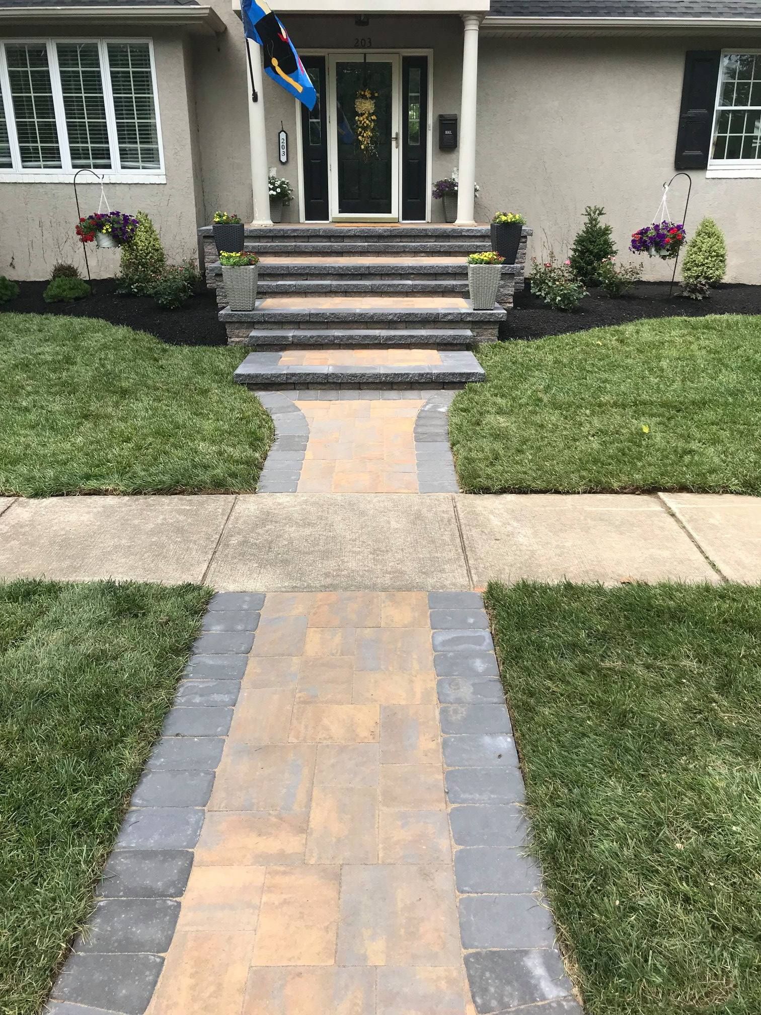 A brick walkway leading to the front door of a house.