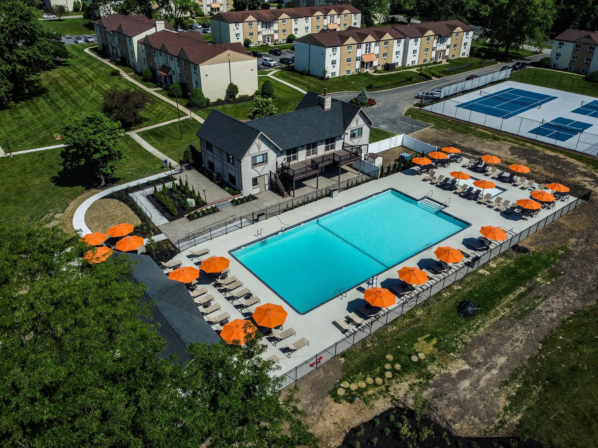 An aerial view of a large swimming pool surrounded by umbrellas and chairs.