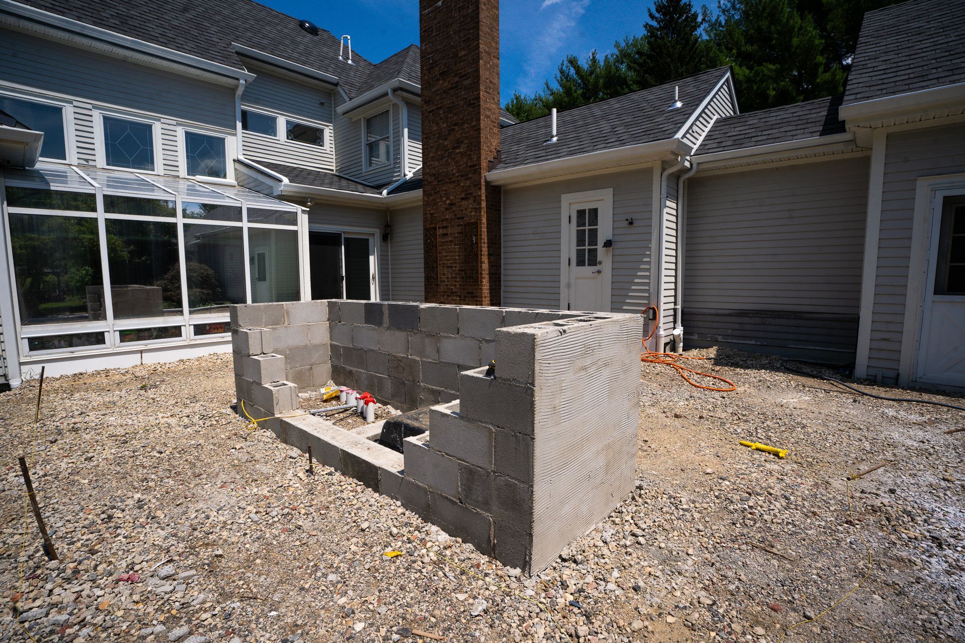 A brick wall is being built in front of a house.