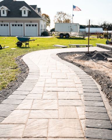 A brick walkway is being built in front of a house.