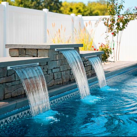 There is a waterfall in the middle of a swimming pool.