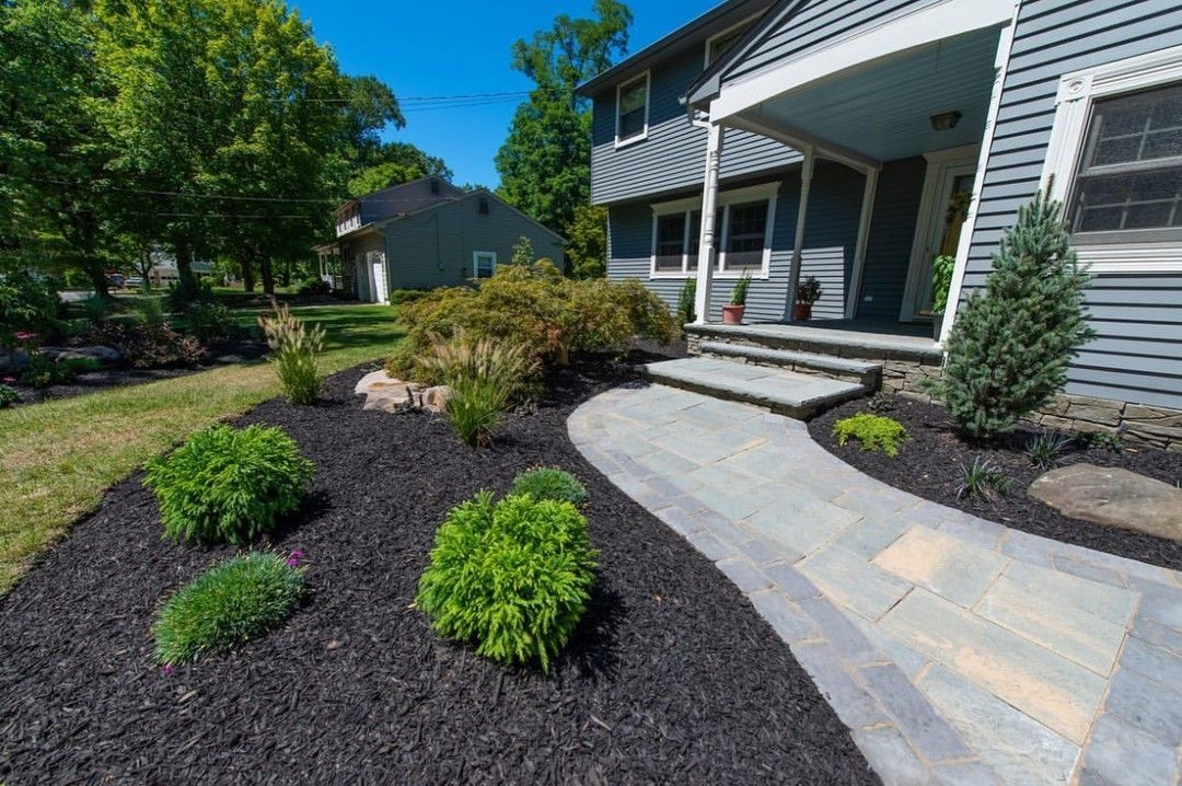 There is a walkway leading to the front of the house.